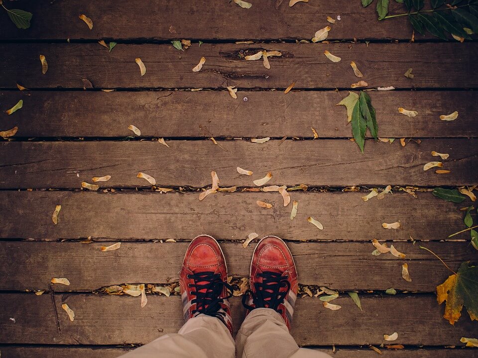 Shoes standing on a deck with leaves